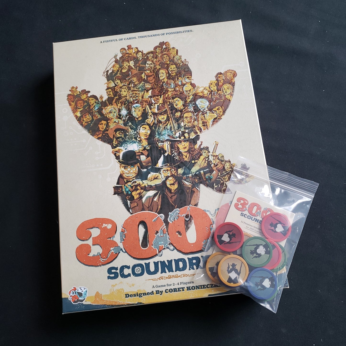 Image shows the front cover of the box of the 3000 Scoundrels board game with a package of promo poker chips on top