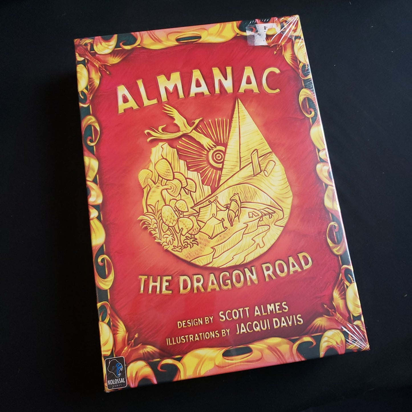 Image shows the front cover of the box of the Almanac: the Dragon Road board game