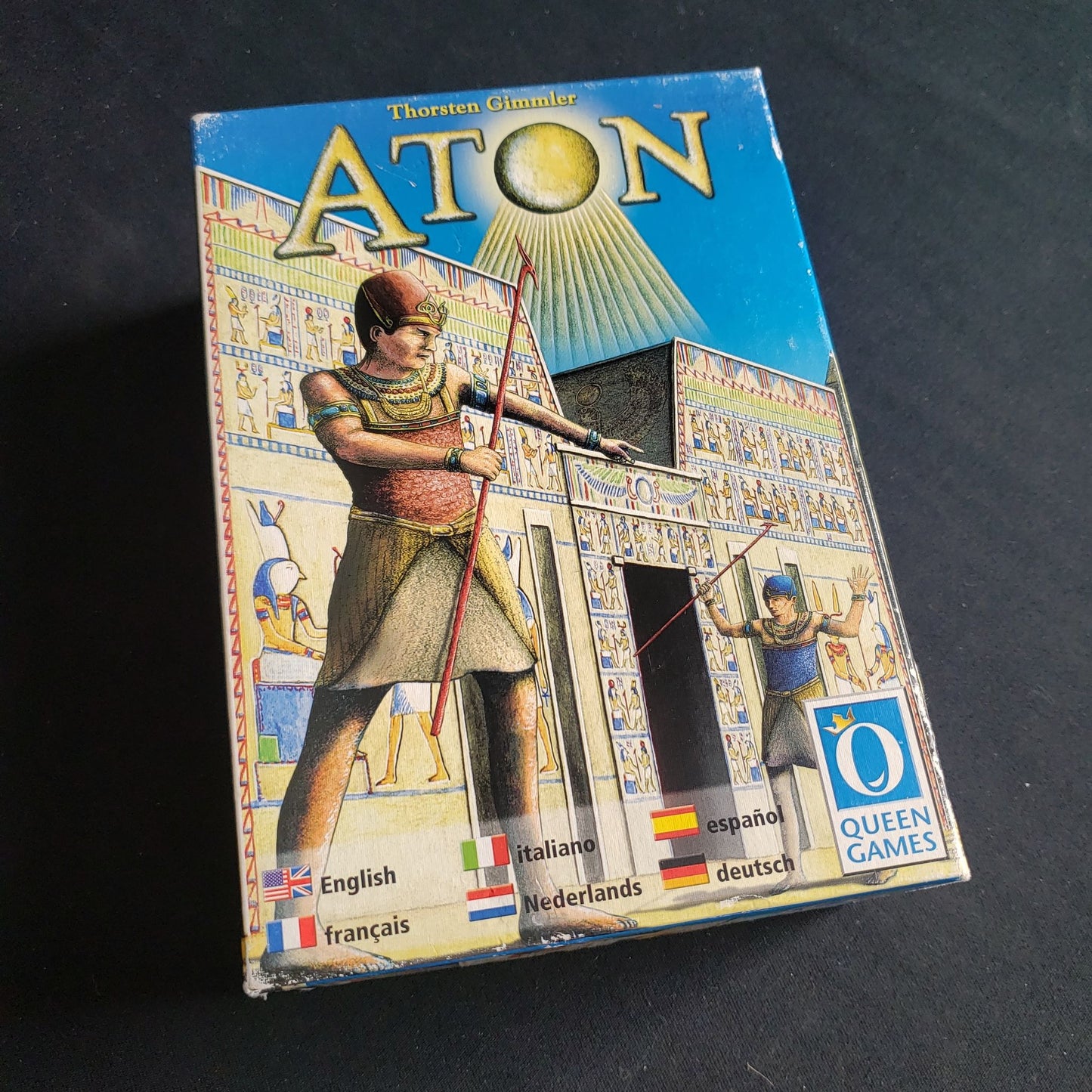 Image shows the front cover of the box of the Aton board game