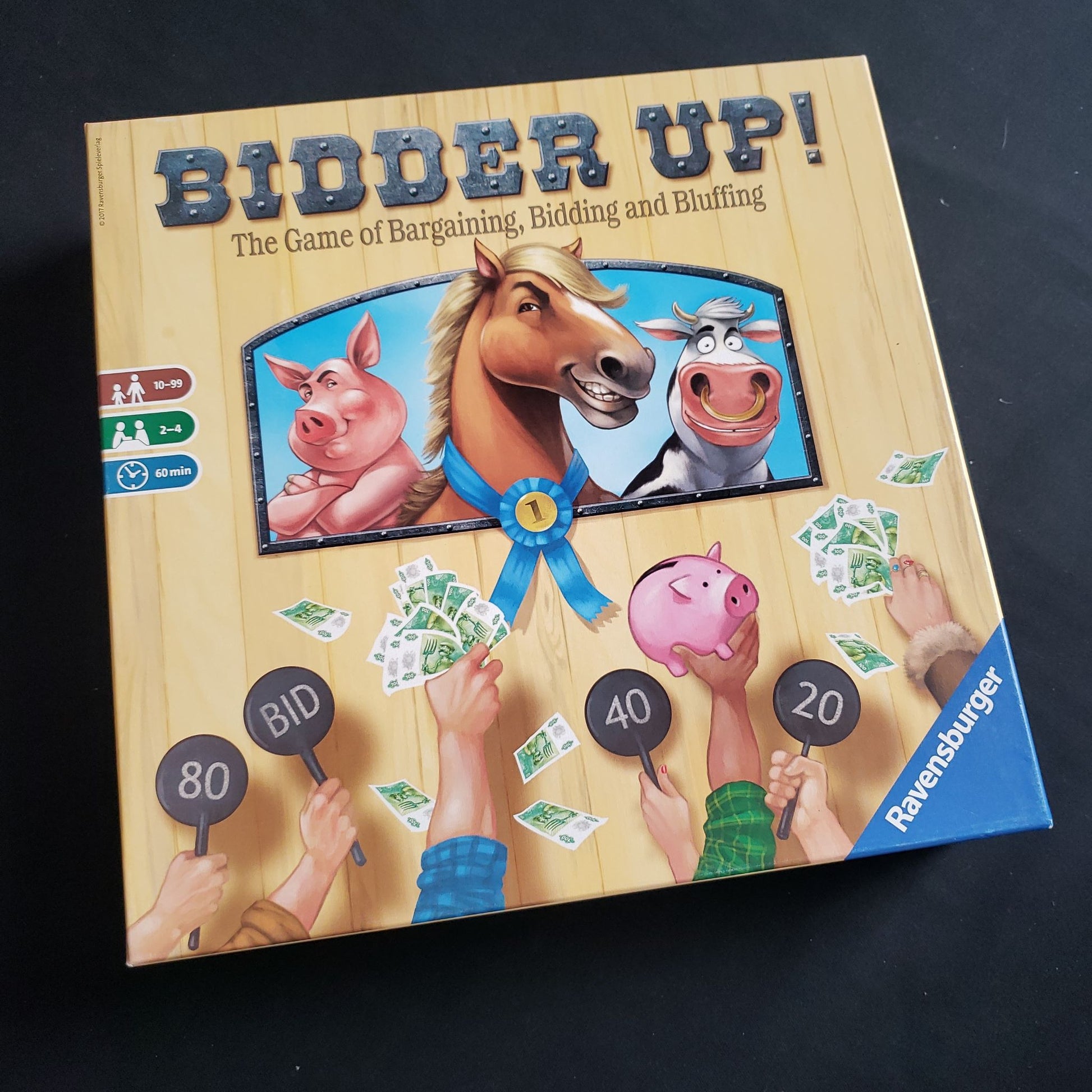 Image shows the front cover of the box of the Bidder Up! board game