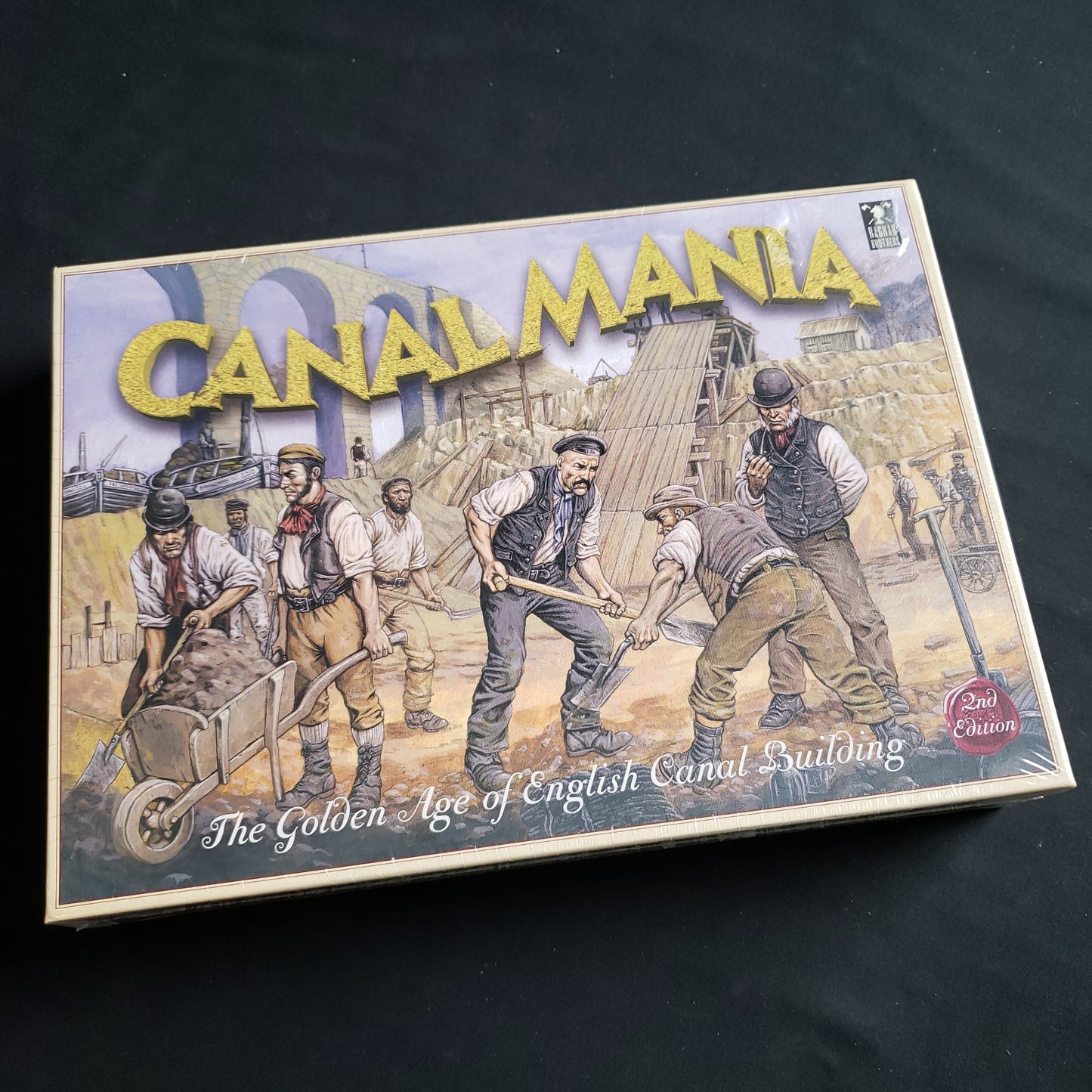 Image shows the front cover of the box of the Canal Mania board game