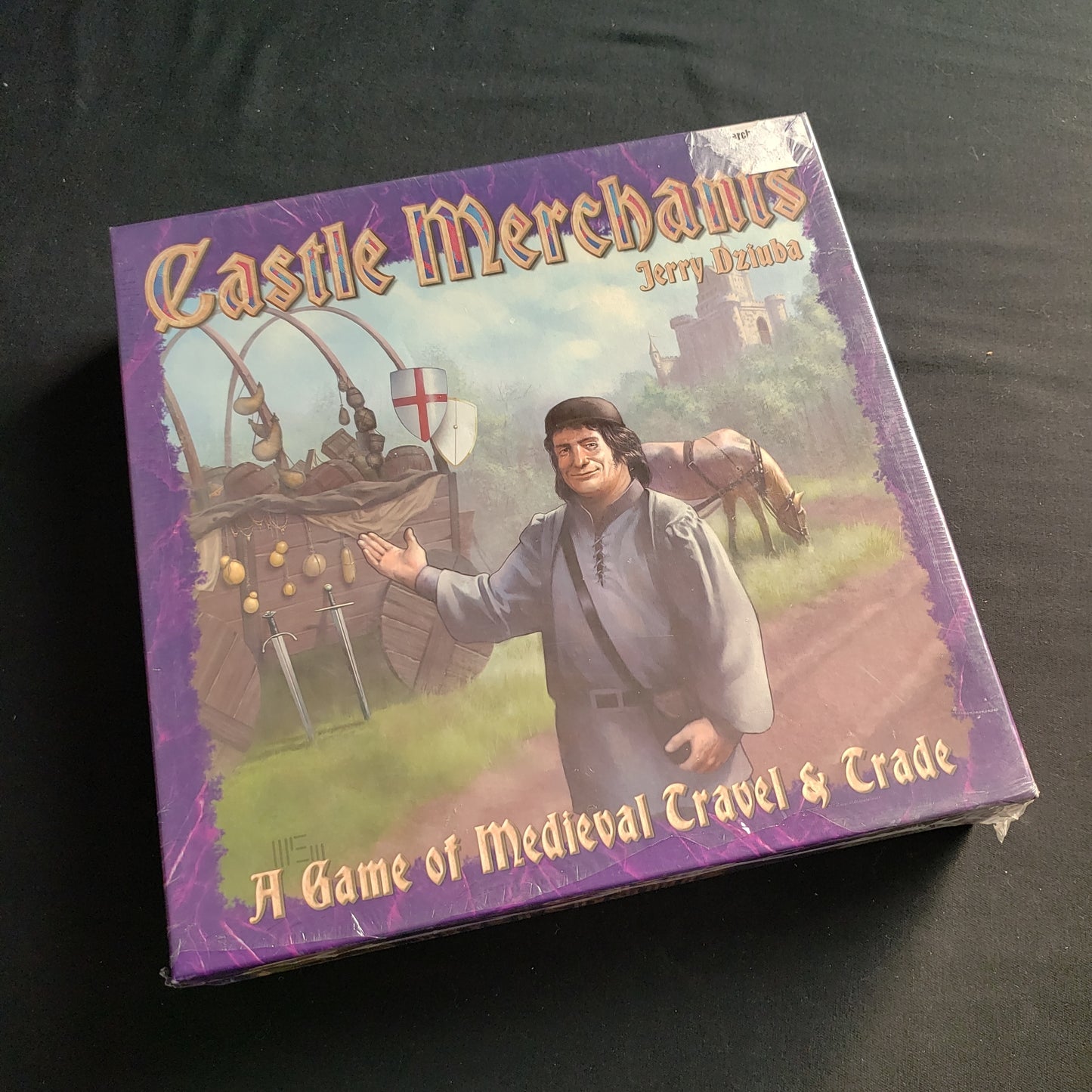 Image shows the front cover of the box of the Castle Merchants board game