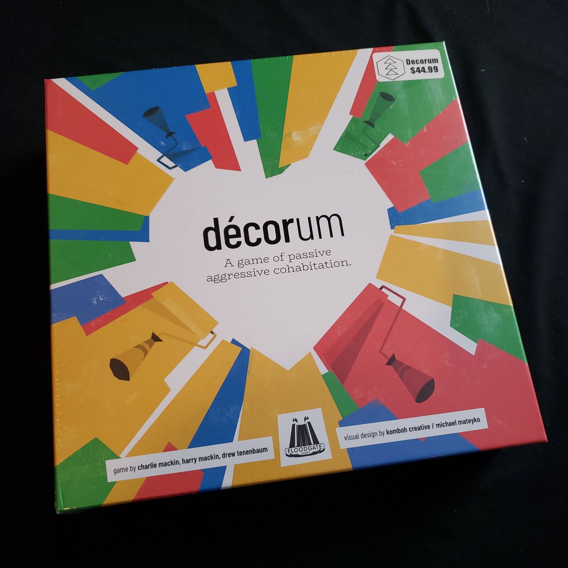 Image shows the front cover of the box of the Decorum board game