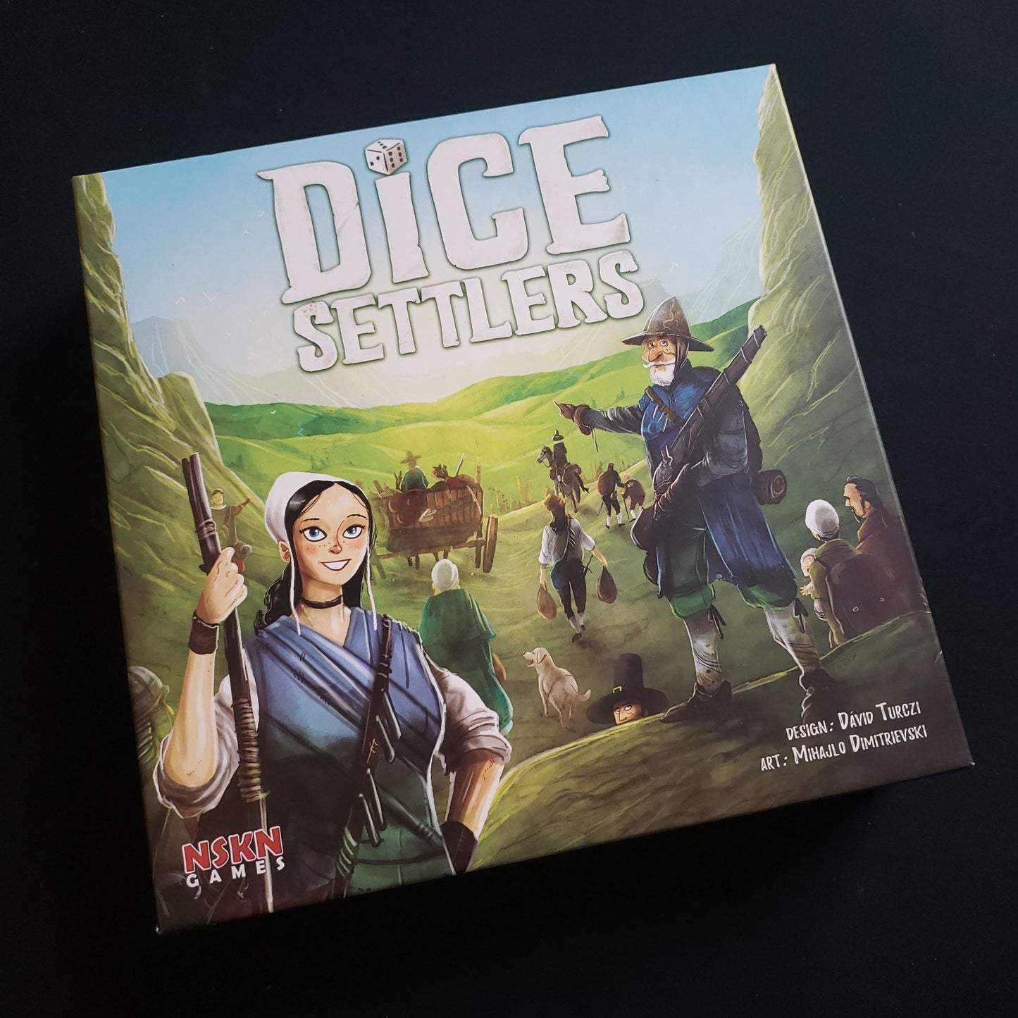 Image shows the front cover of the box of the Dice Settlers  board game