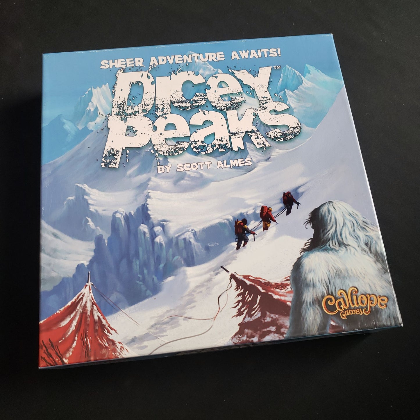 Image shows the front cover of the box of the Dicey Peaks board game