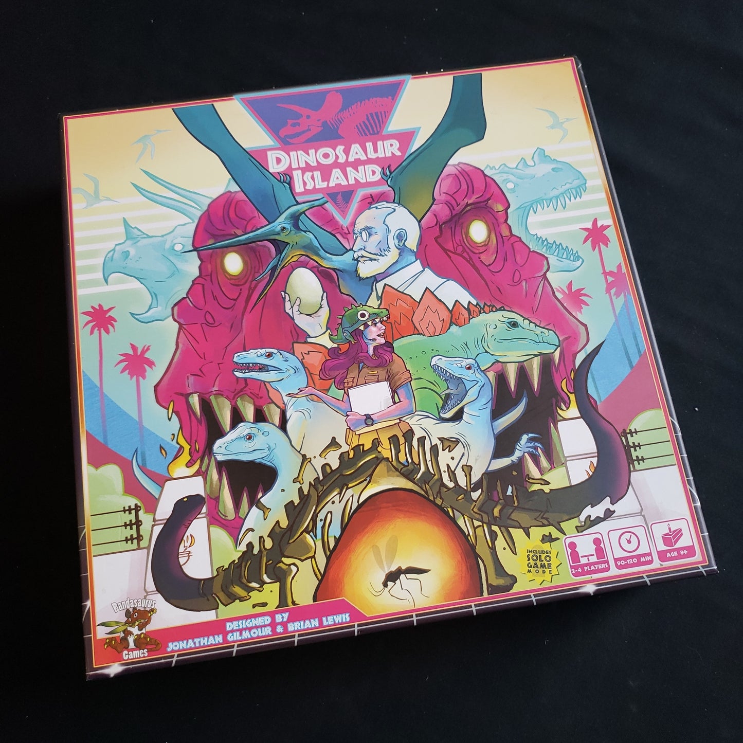 Image shows the front cover of the box of the Dinosaur Island board game