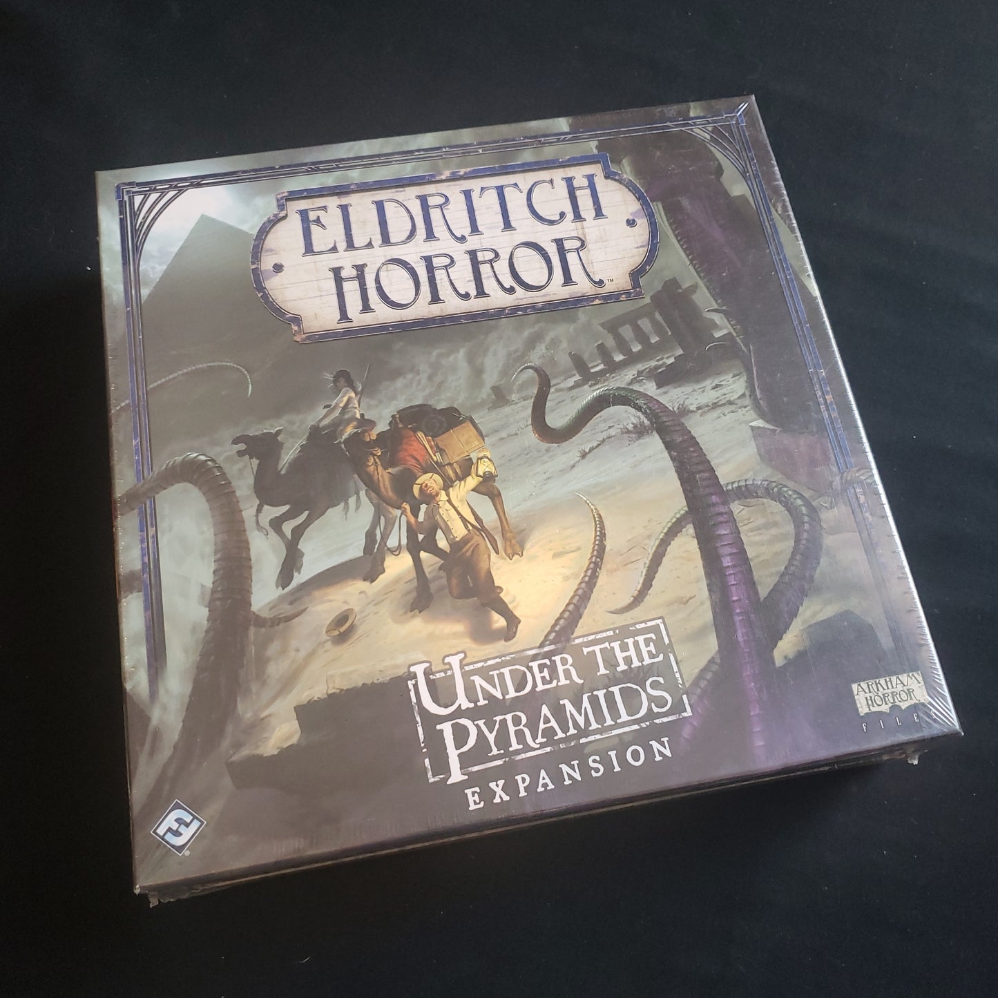 Image shows the front cover of the box of the Under the Pyramids expansion for the Eldritch Horror board game