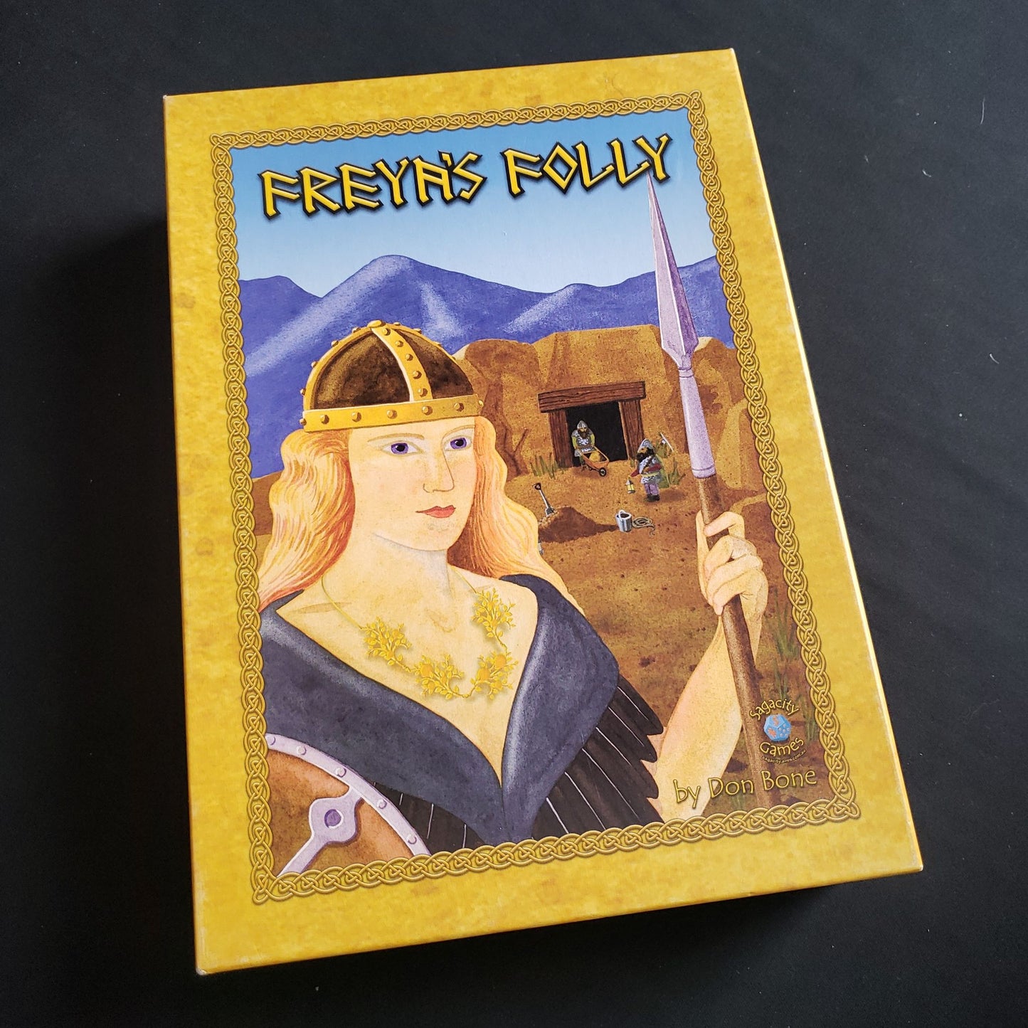 Image shows the front cover of the box of the Freya's Folly board game