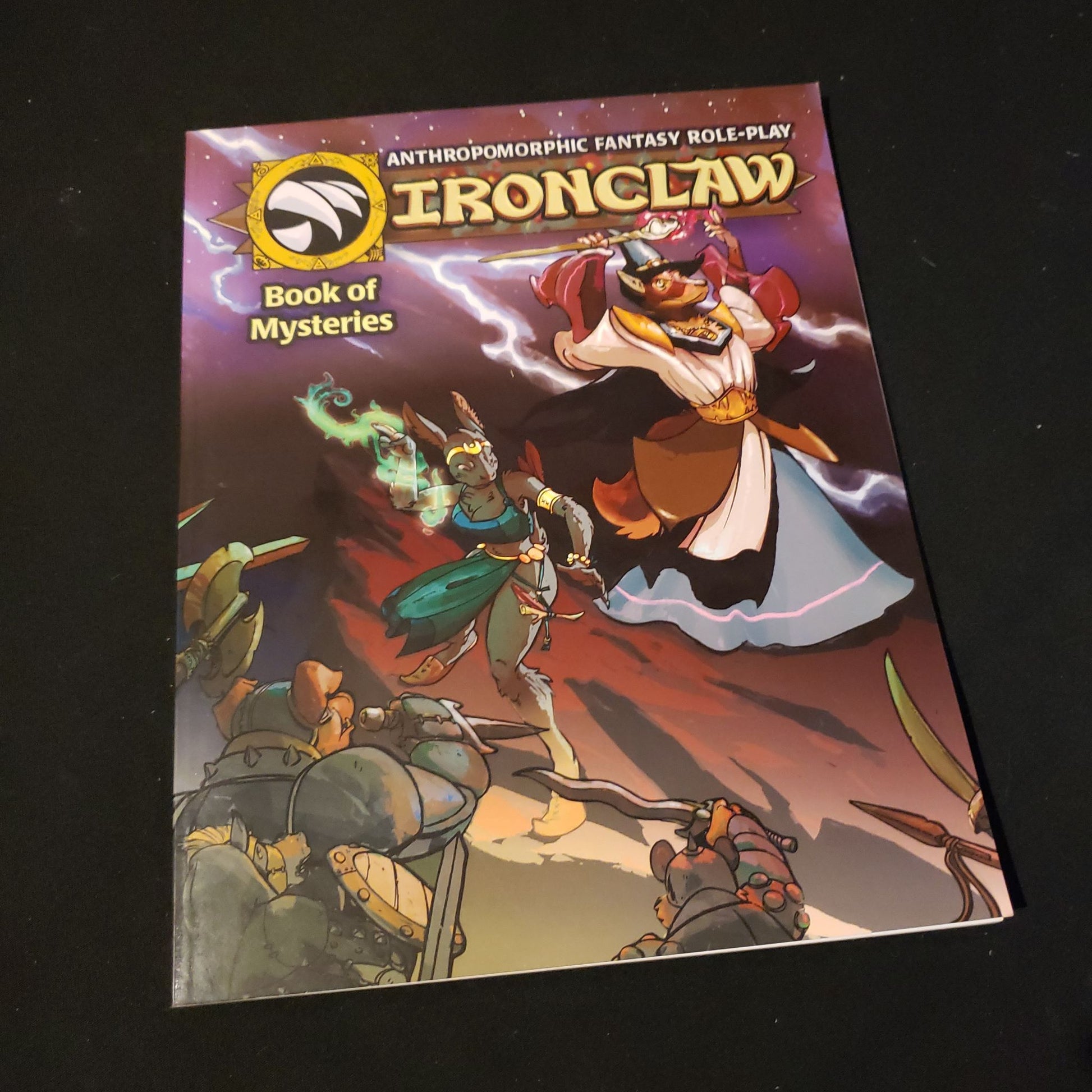 Image shows the front cover of the Book of Mysteries for the Ironclaw roleplaying game