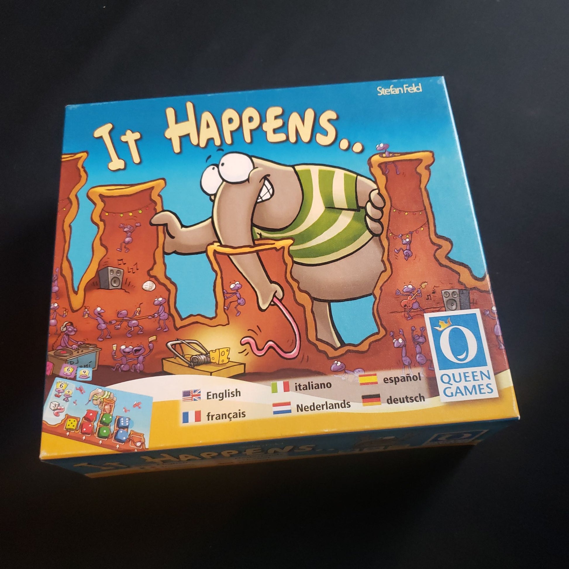 Image shows the front cover of the box of the It Happens board game