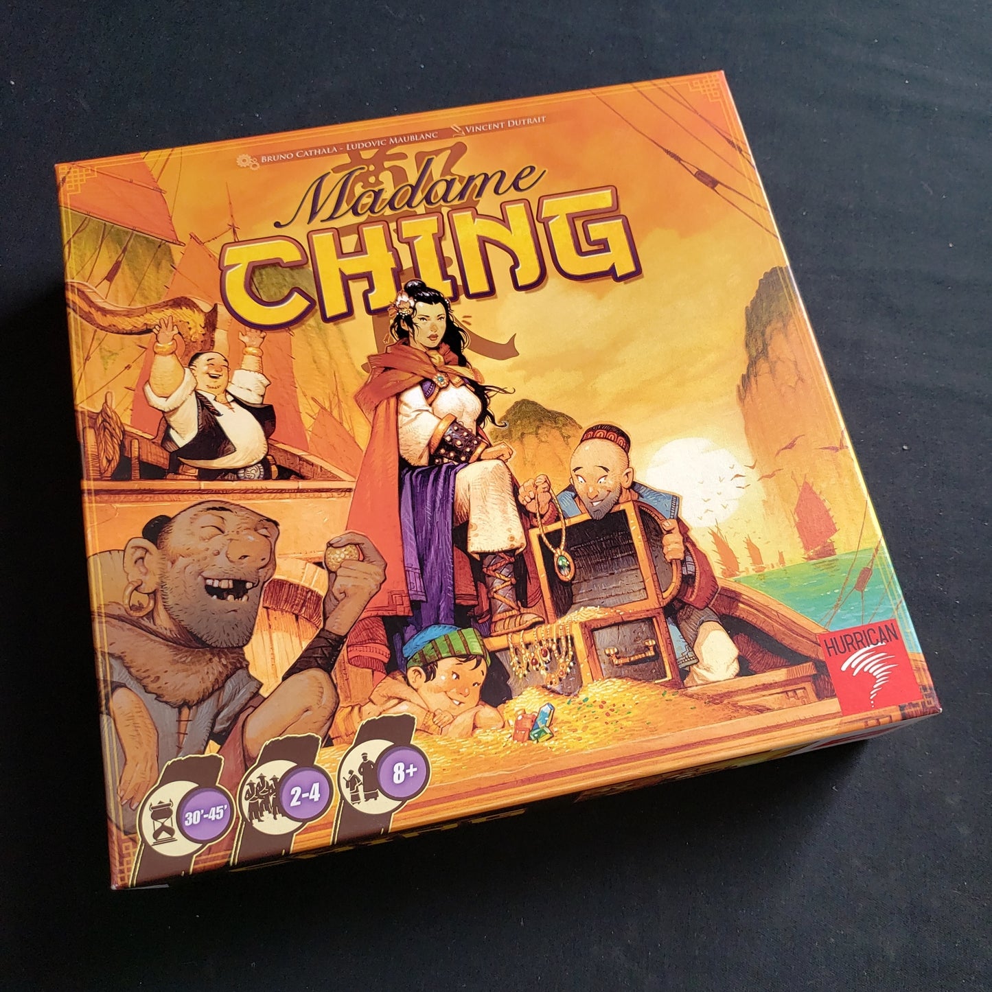 Image shows the front cover of the box of the Madame Ching board game
