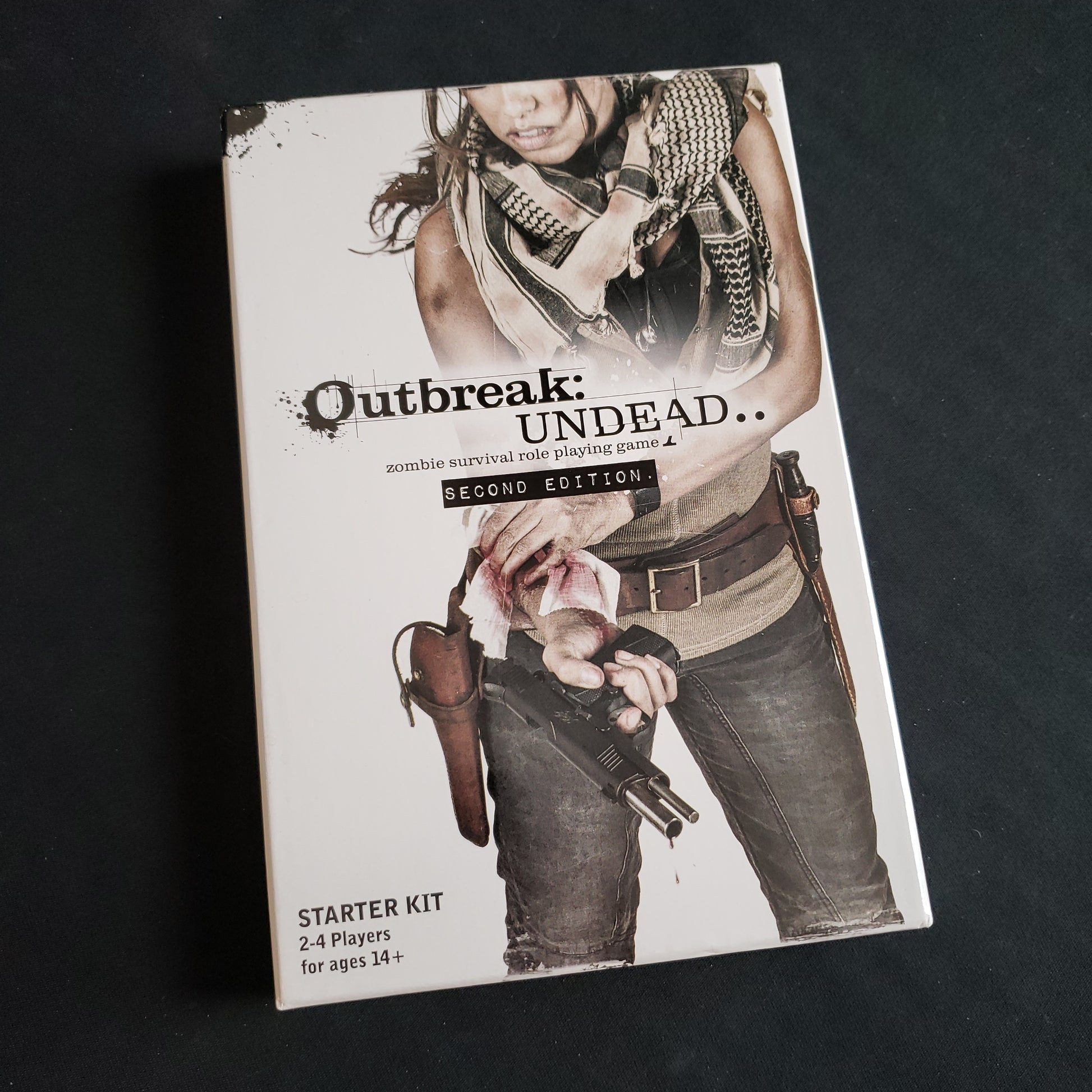 Image shows the front cover of the box of the second edition Starter Kit for the Outbreak: Undead roleplaying game