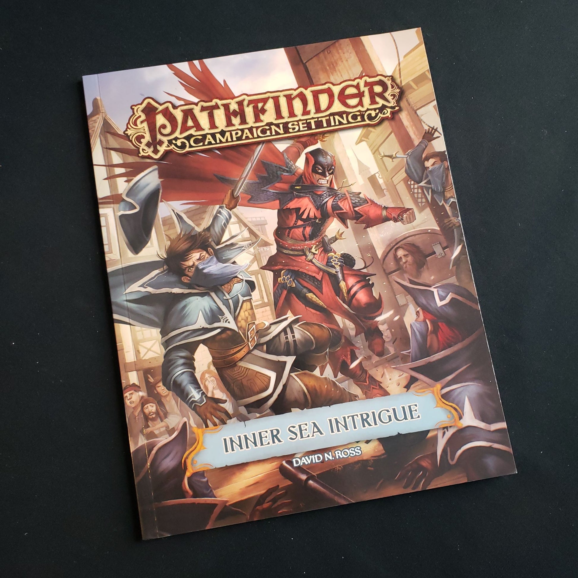 Image shows the front cover of the Inner Sea Intrigue book for the Pathfinder First Edition roleplaying game