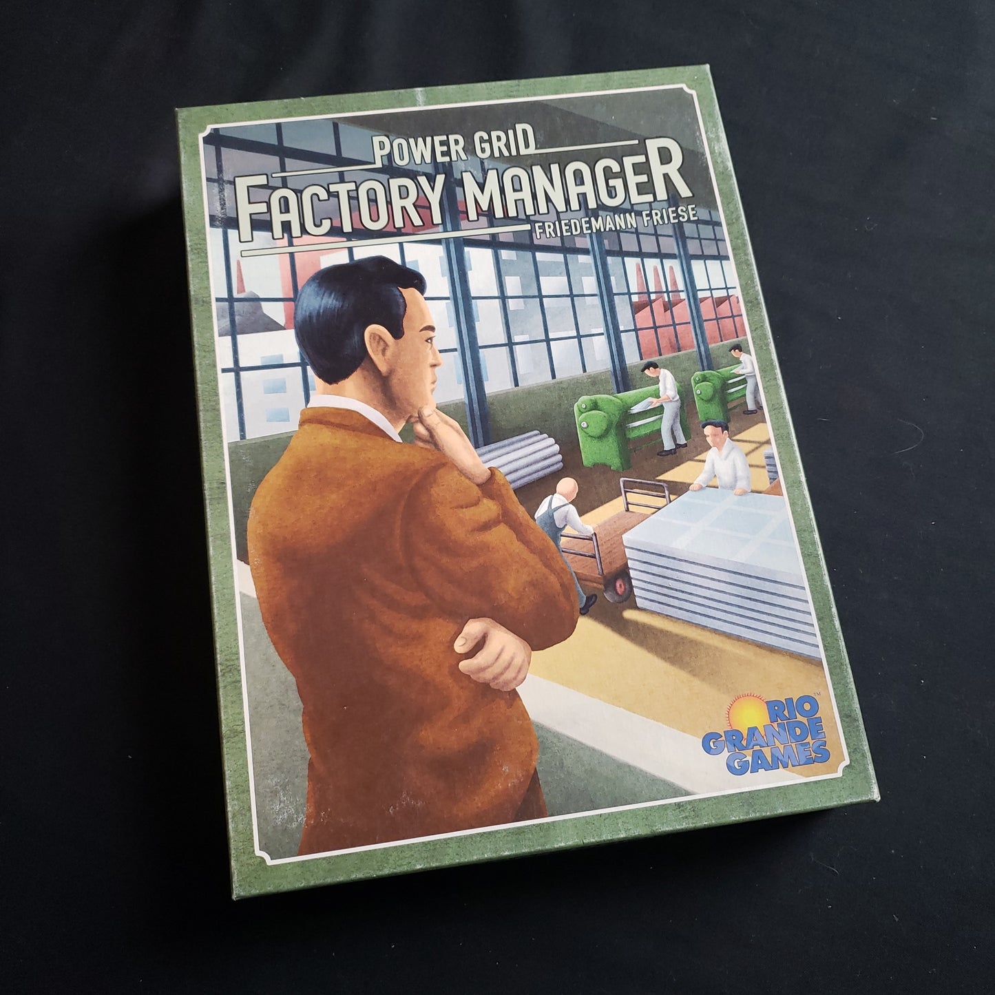 Image shows the front cover of the box of the Power Factory: Factory Manager board game