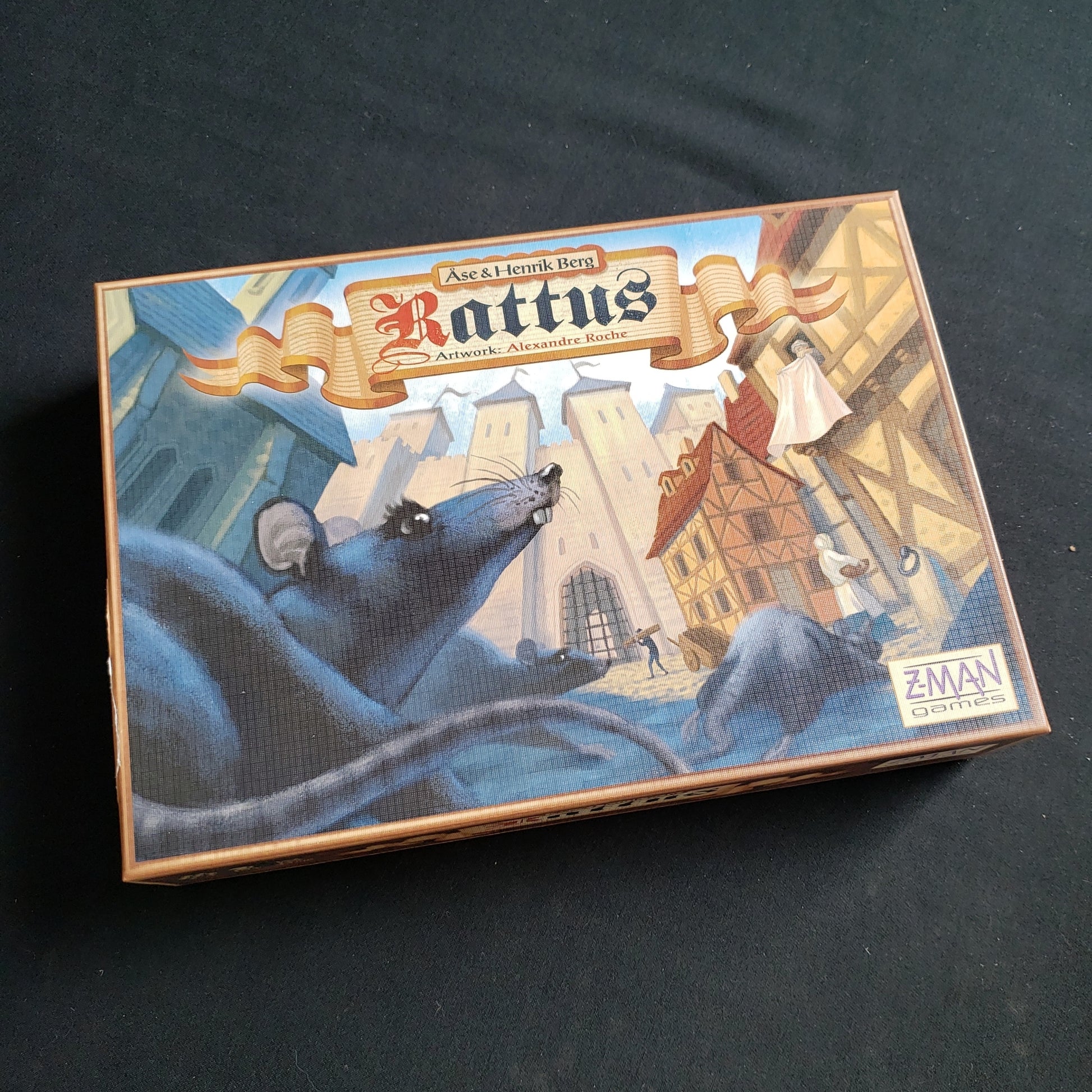 Image shows the front cover of the box of the Rattus board game