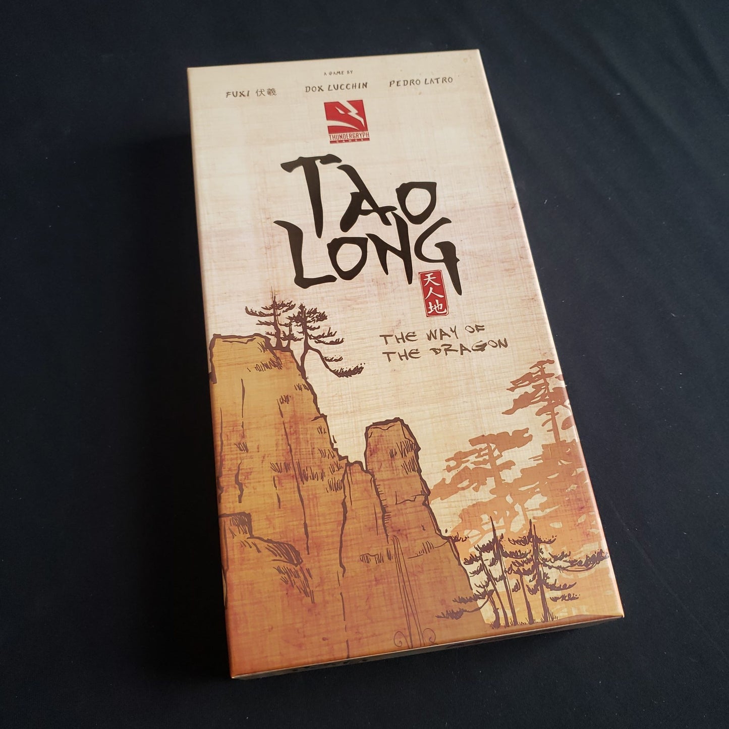 Image shows the front cover of the box of the Tao Long board game