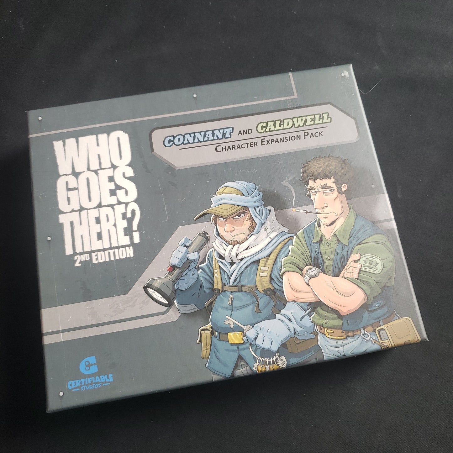 Image shows the front of the box for the Connant and Caldwell Character Expansion Pack for the Who Goes There board game