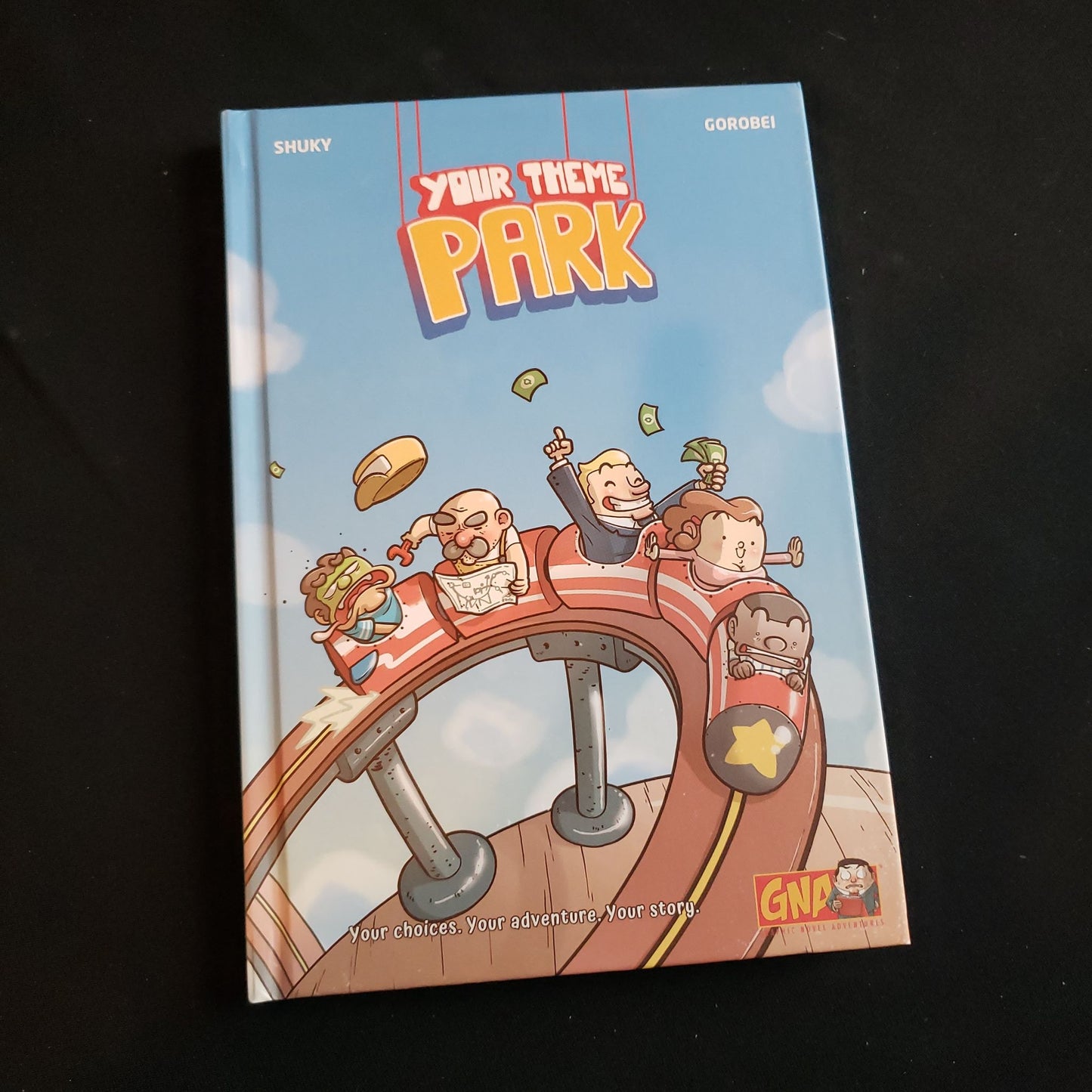 Image shows the front cover of the Your Theme Park game book